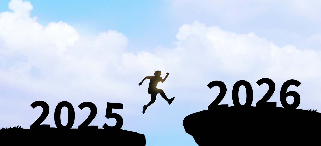Silhouette of a person jumping across a gap from 2025 to 2026 against a blue sky.